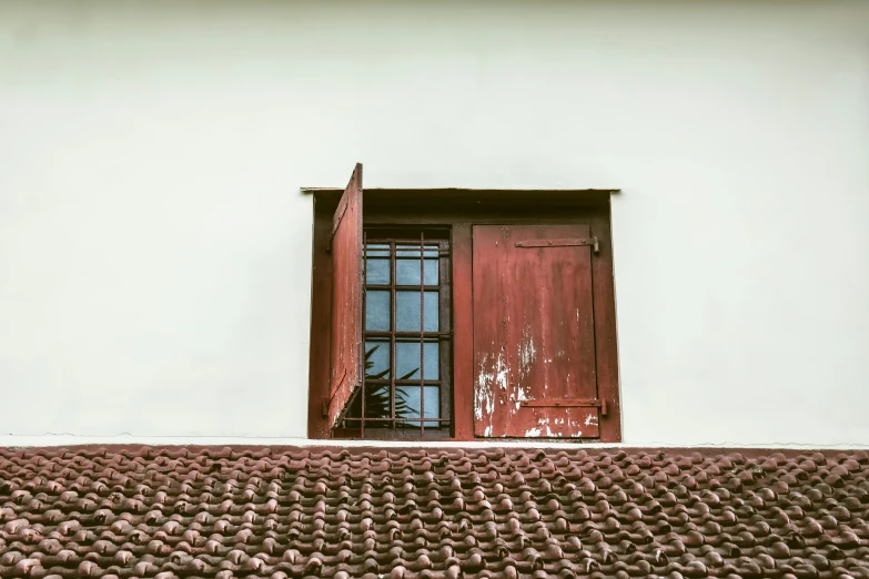 a red window next to a white wall