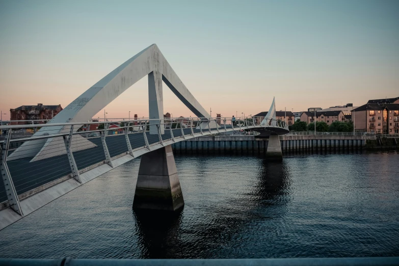 a bridge that runs over the water leading to buildings