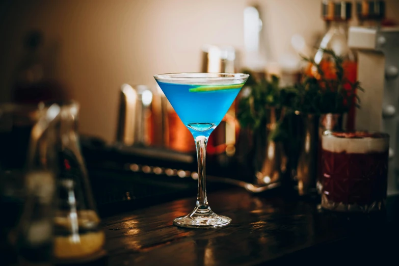 the blue martini is sitting on a bar