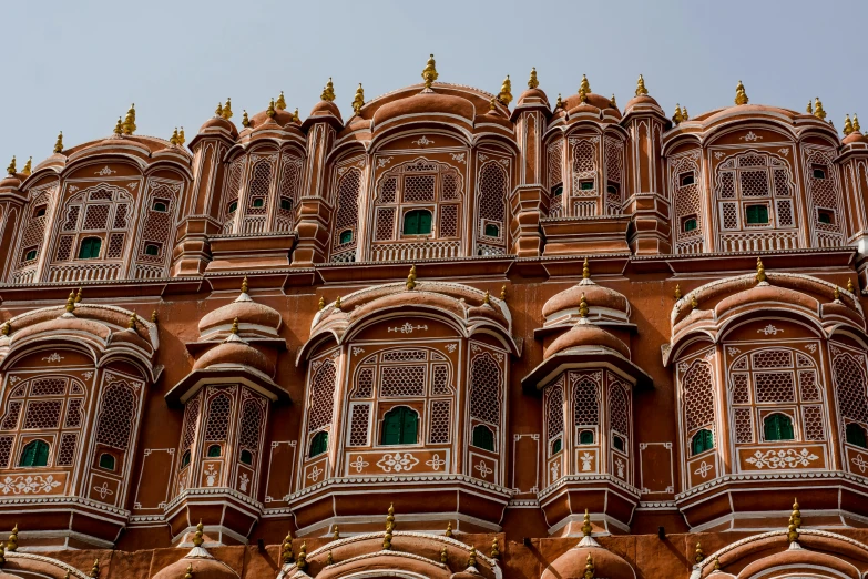 the ornate architecture of a building stands behind the blue sky