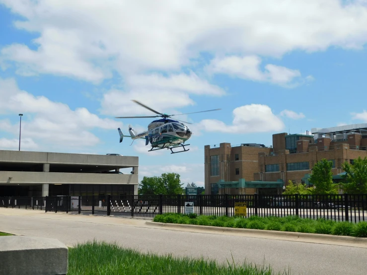 a helicopter is flying over the grass and building