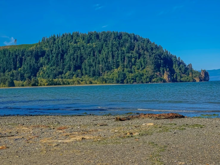 a mountain near water and green trees