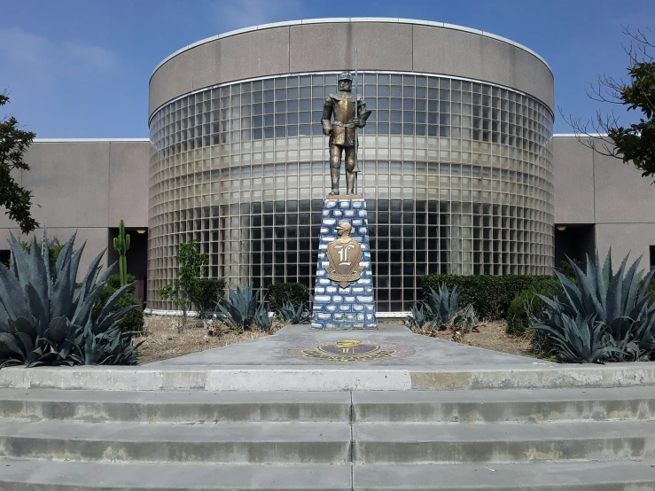 a statue sitting in front of a circular building