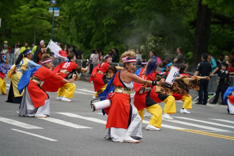 many people in red and yellow dress dancing in a parade