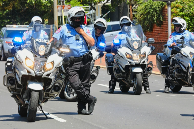 several police officers on motorcycles drive down the street