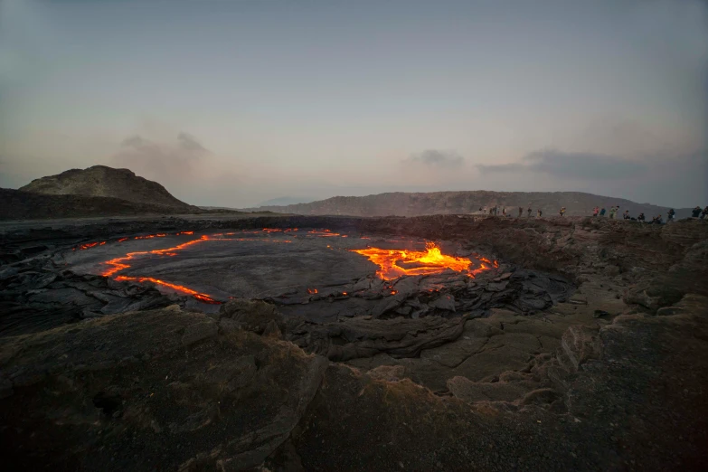 lava covered ground with small yellow flames on the ground