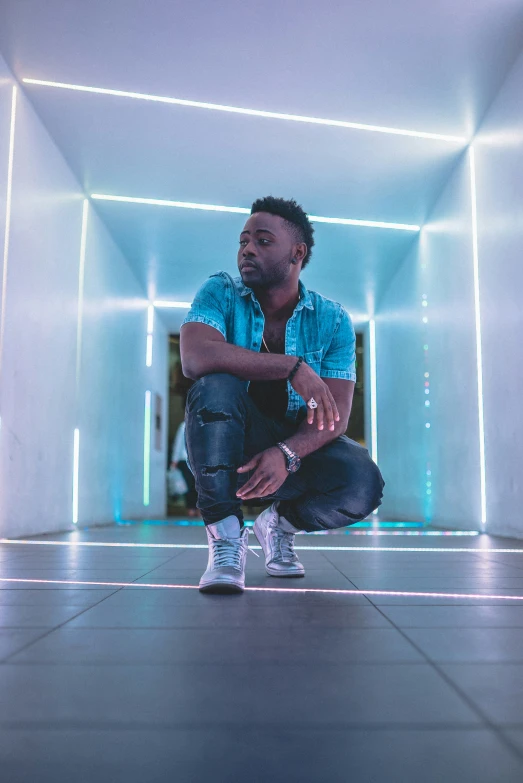 a man in sneakers squatting down with his legs crossed