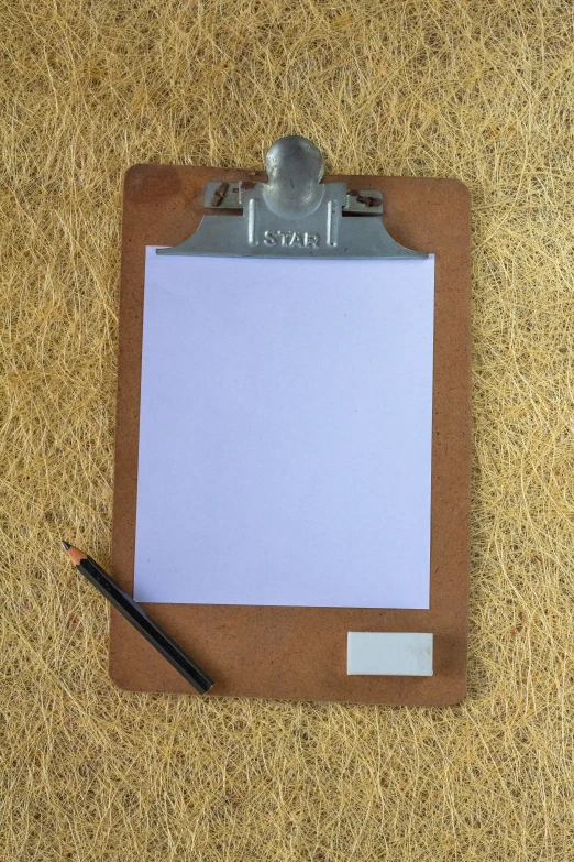 a clipboard is placed on the carpet with paper stuck to it