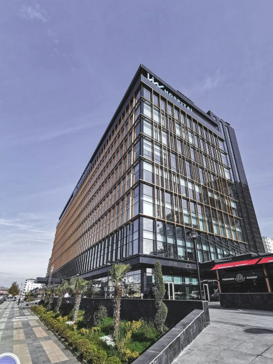 an office building with trees and shrubbery around it