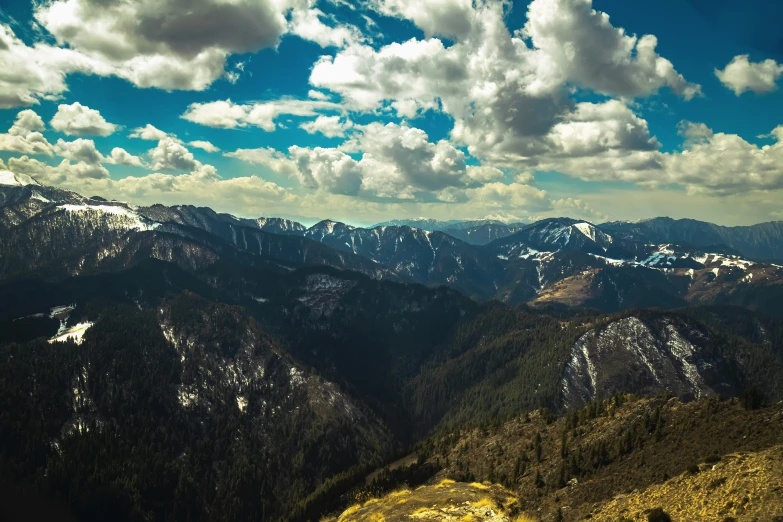 the snow covered mountains are seen from the top of a hill