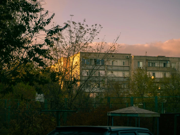 a car driving through a parking lot with tall buildings in the background