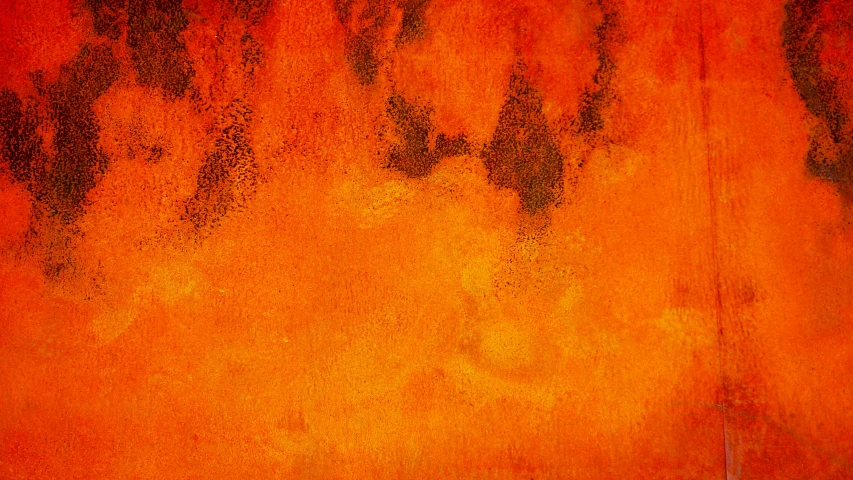 a rusty orange paint wall with many different stains