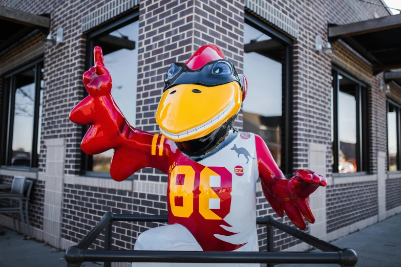 the plastic mascot is pointing at someones hand