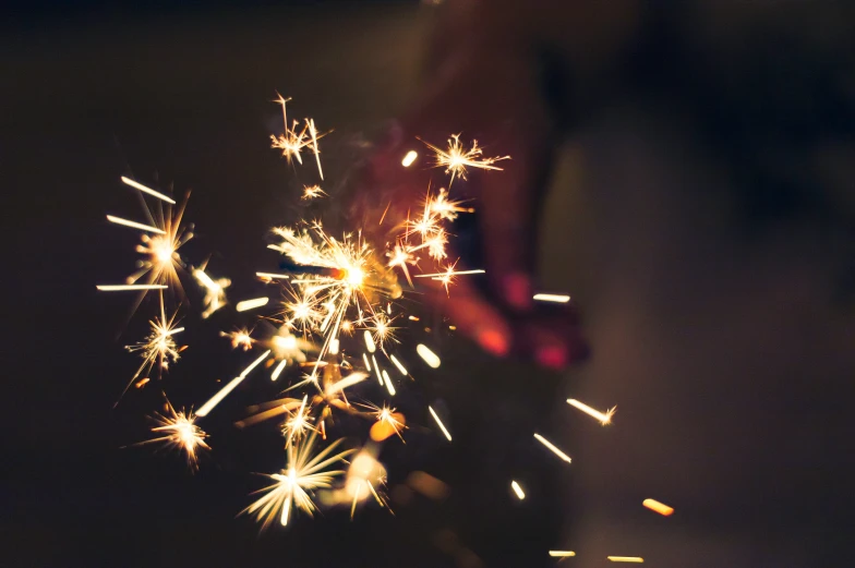 a man holding a lit sparkler in his hand