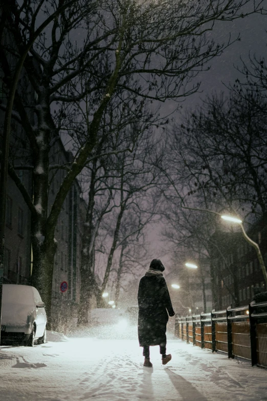 the man in winter clothes is walking down the street