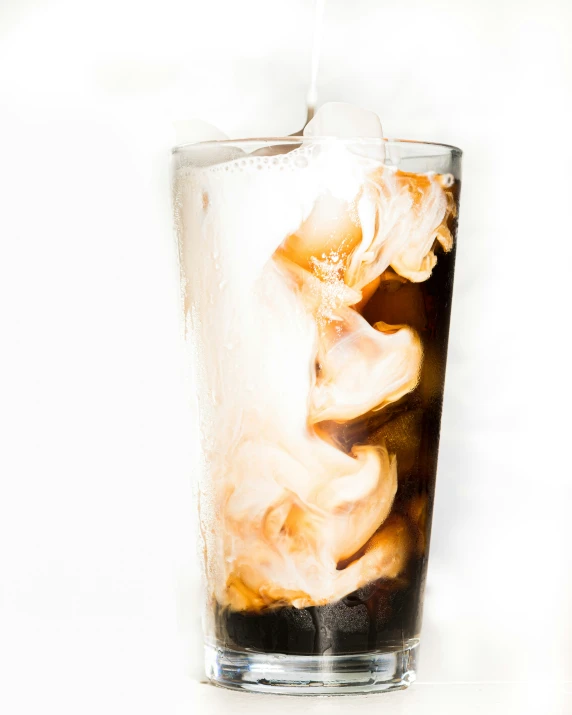 a beverage in a glass with ice and liquid