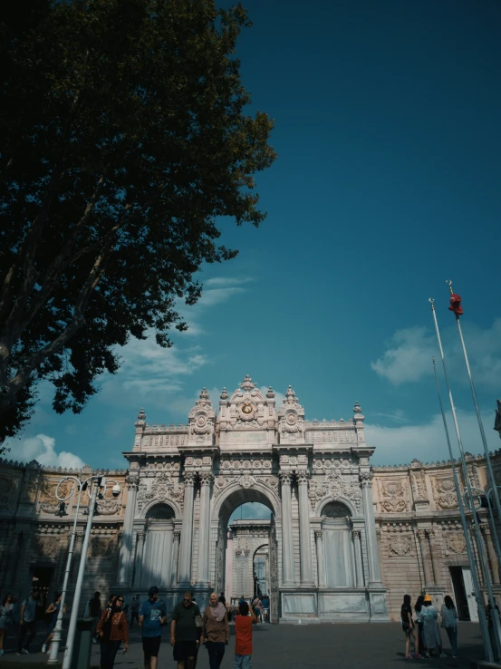 several people are standing outside an arch in a city