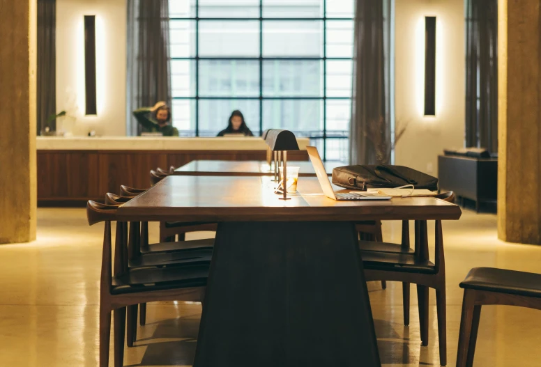 a woman is seen in the background as people work at a large table