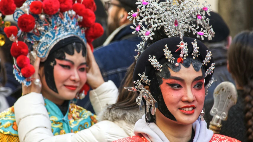 two woman wearing different costumes and colorful headgear