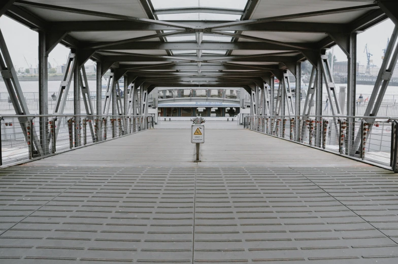 a view of a walkway, which has several poles, and a train