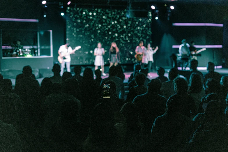 a crowd of people watching a band on stage