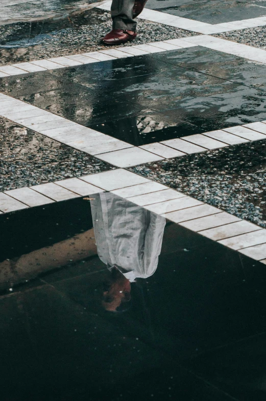 a person walking down a street near a dle of water