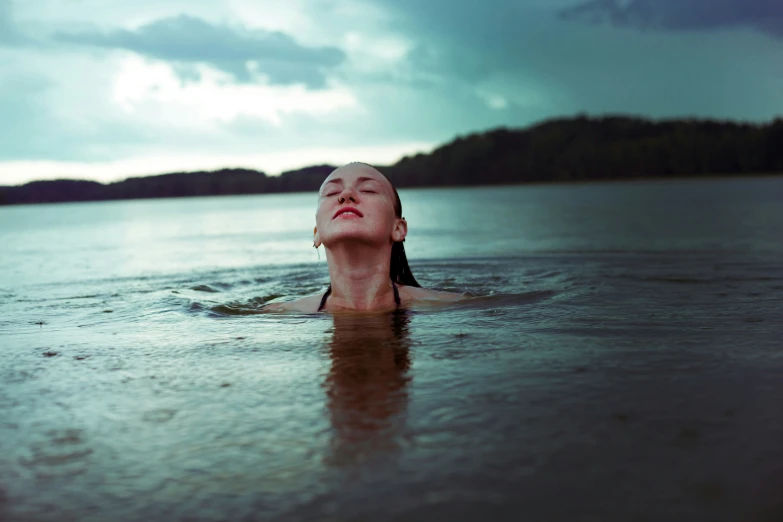 a woman floating in water with her head in the water