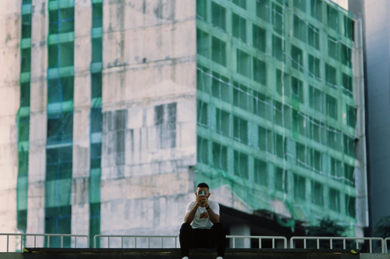 a man on a cell phone standing next to buildings