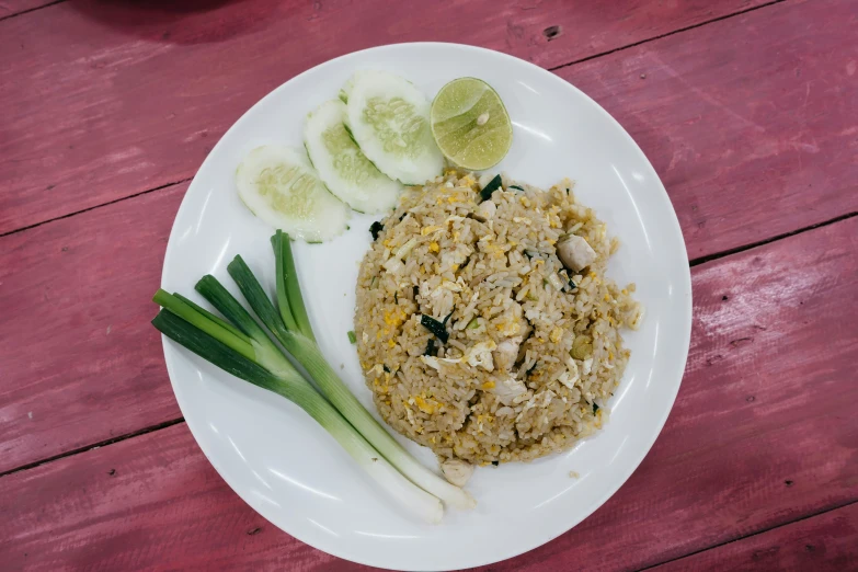 there is an appetizing meal with onion, rice, cucumbers and ginger on the plate