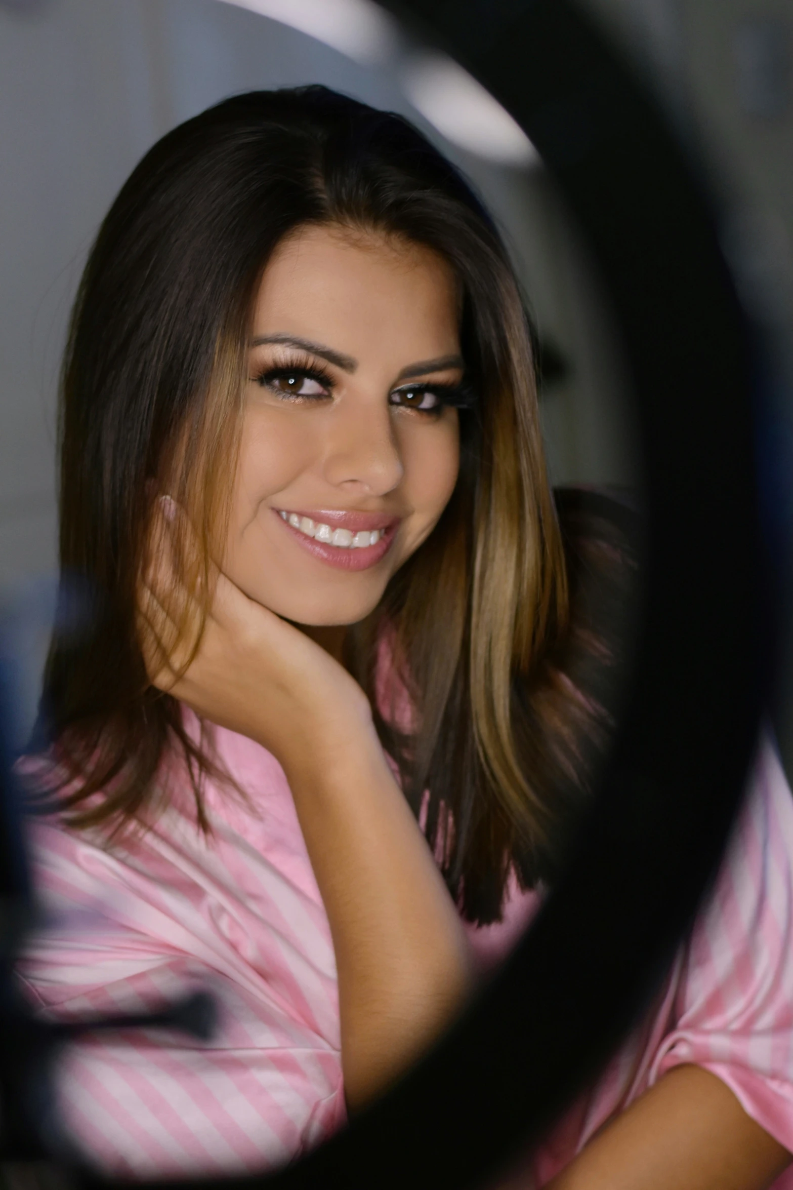 woman smiling in a robe and towel sitting by a mirror