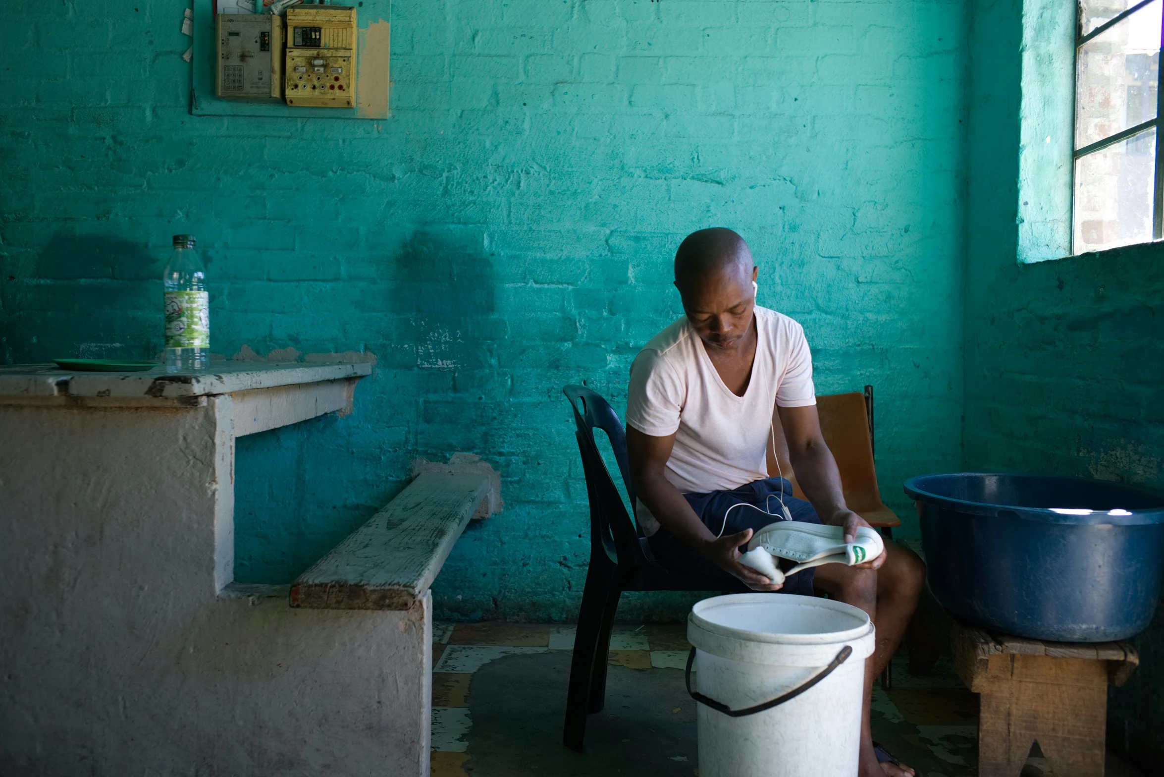 the man is sitting down with a bucket of dishes