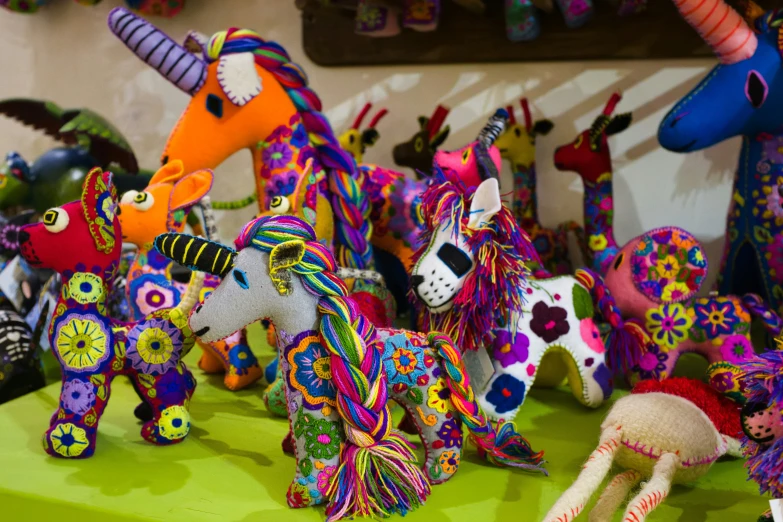 colorfully painted plastic horses are displayed on a green table