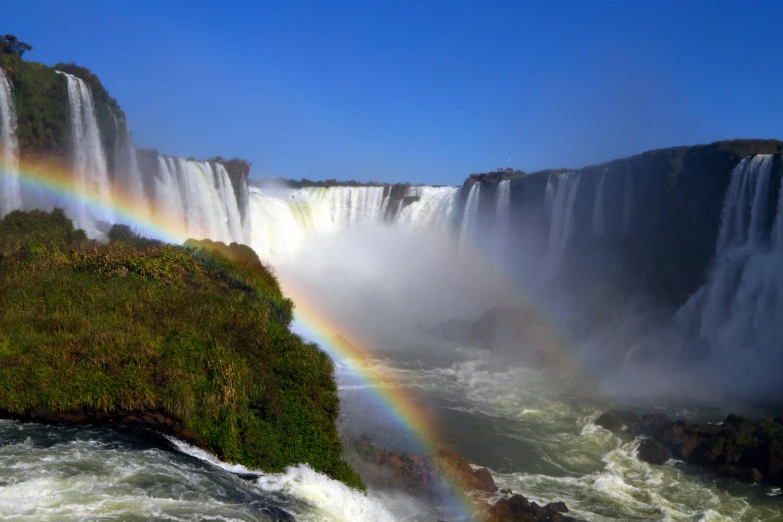 a large waterfall with a rainbow in the middle