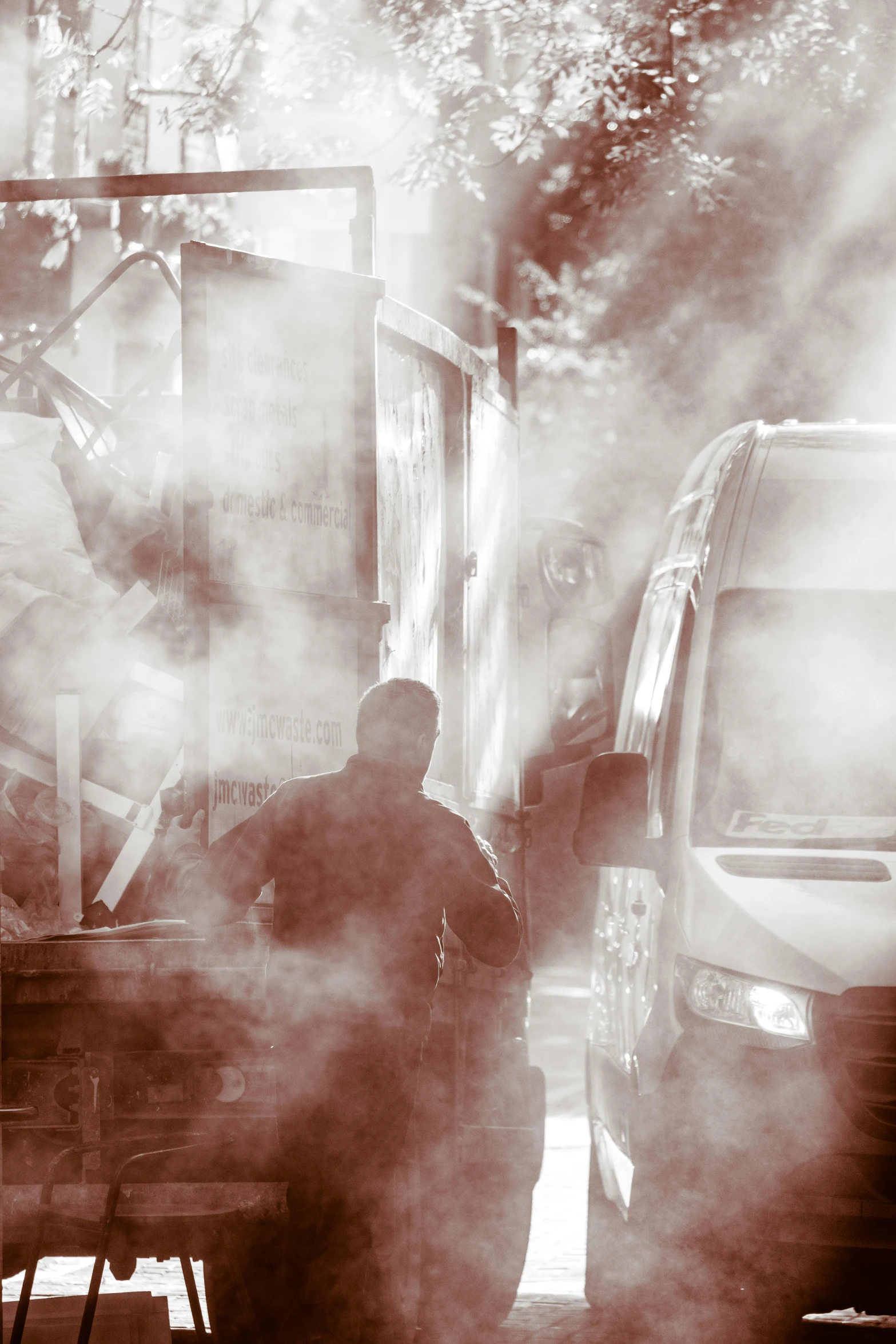 smoke rises from a man standing next to a van