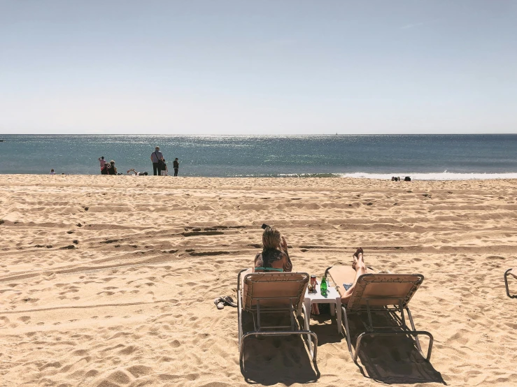 a couple sit at a table on the beach