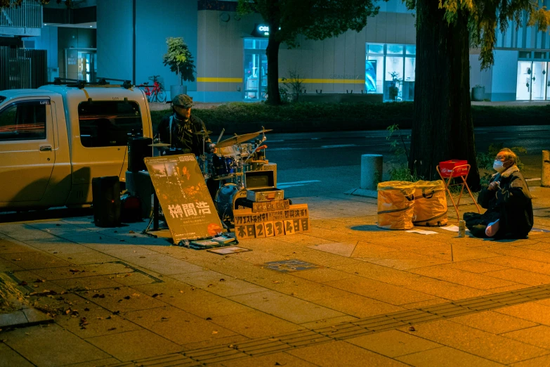 people sitting on the side of the street, near an van