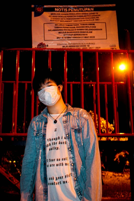 a man in a blue jacket standing outside of a red fence