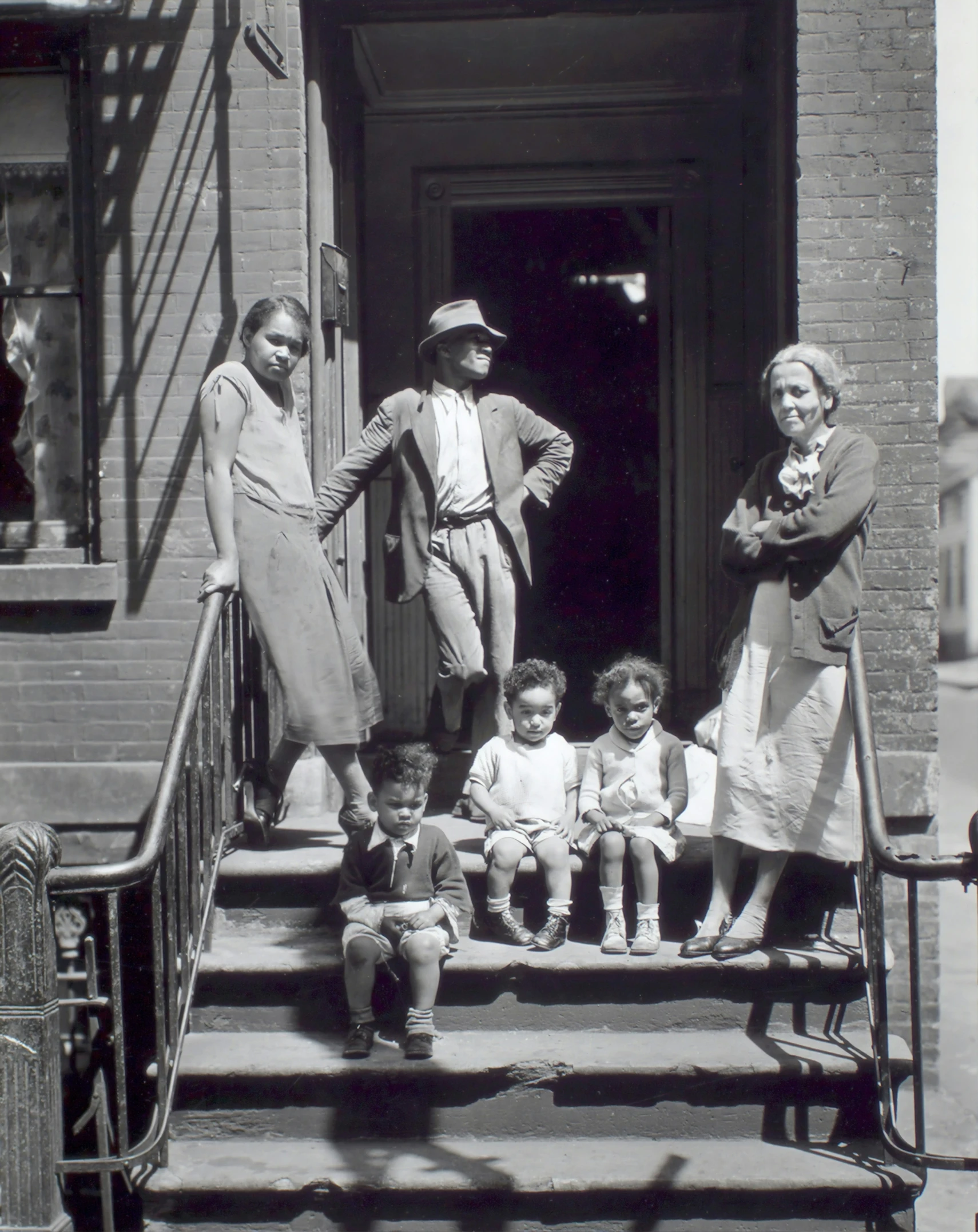 an old po of two children standing outside of a home