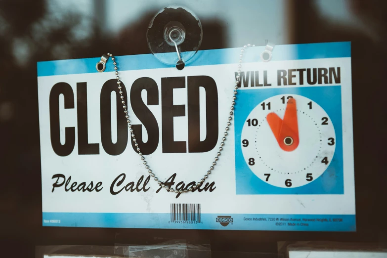 a close up of a clock sign behind a glass