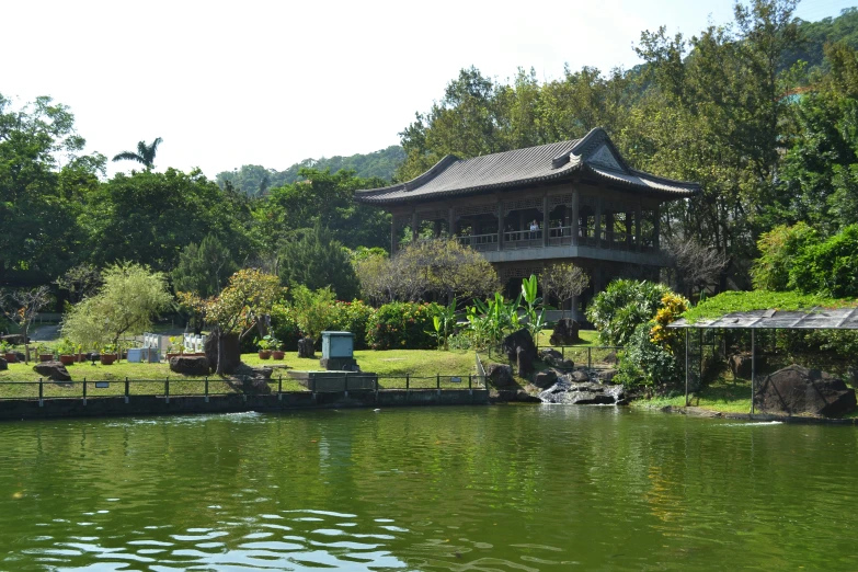 a building with a pavilion in front of it by the water