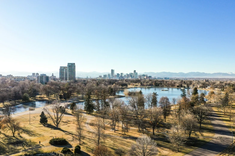 a picture of a city with a lake and the trees