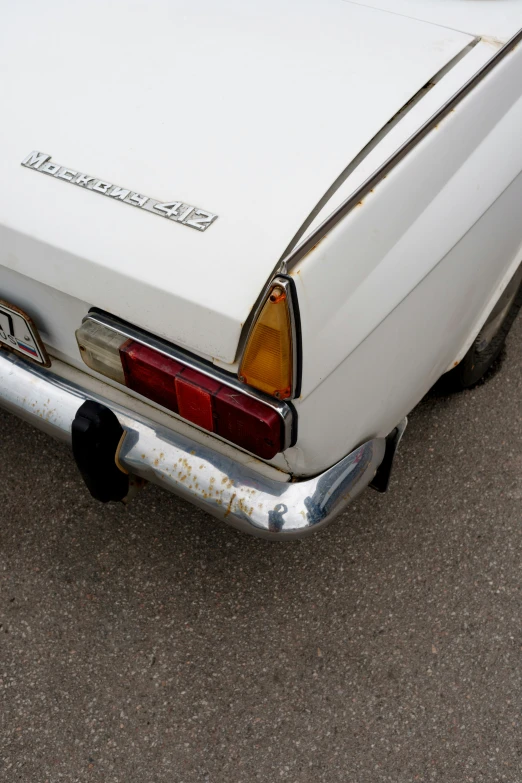 an old car with faded fender fenders parked on the street