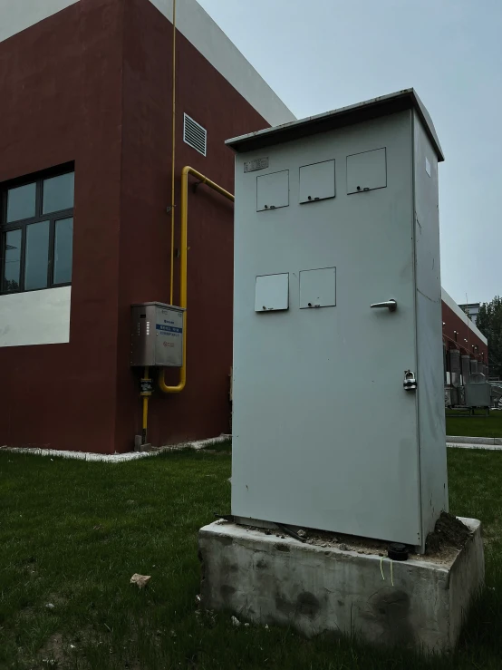 a gray structure sits in the middle of some grass