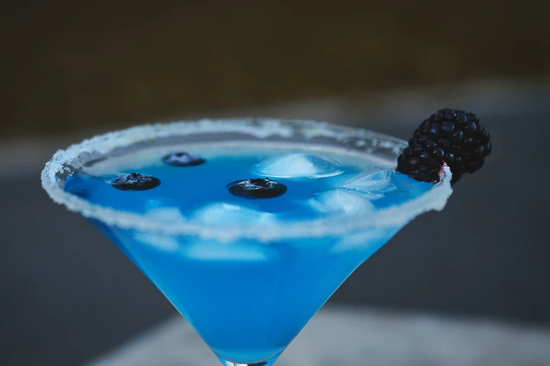 a blue drink that is topped with a berry