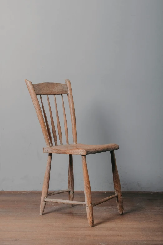 a wooden chair sitting on top of a wood floor