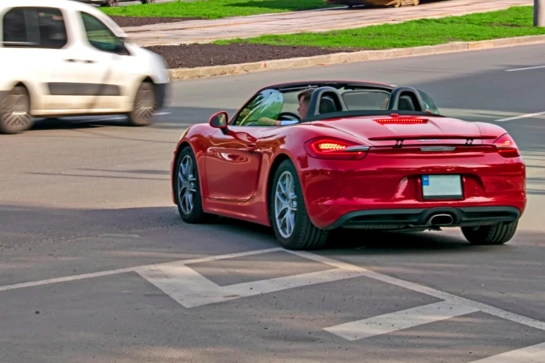 a red sports car is driving down a busy road