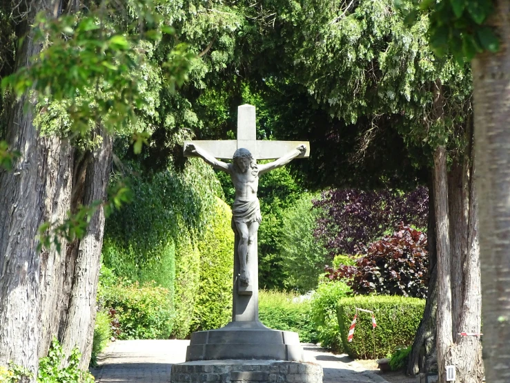 a cross in a cemetery surrounded by trees