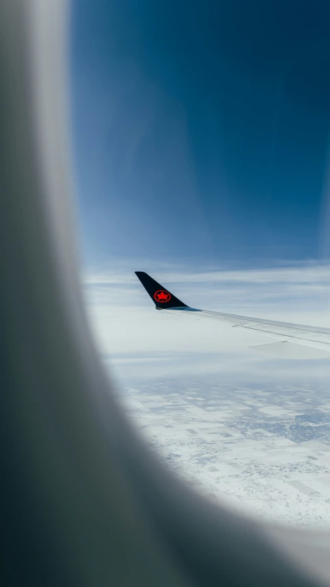 an airplane is flying in the sky over some snow