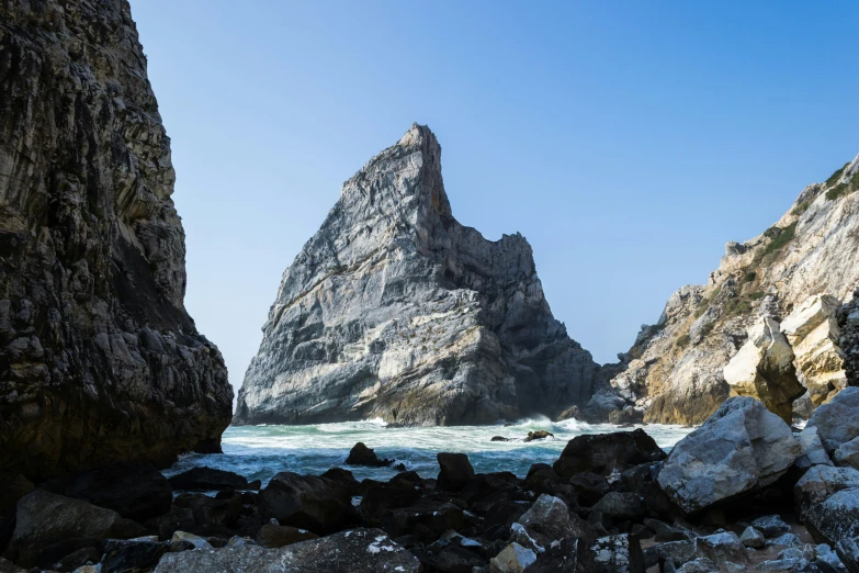 a rock formation near a body of water and large rocks