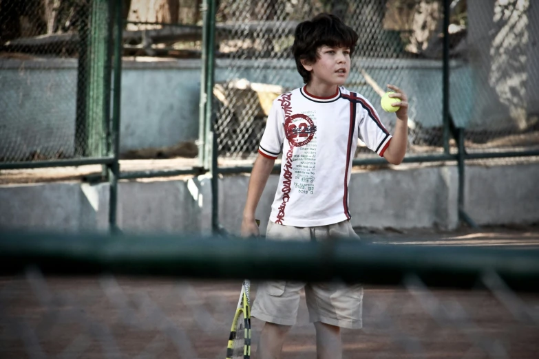 a young man holding a tennis racquet and ball